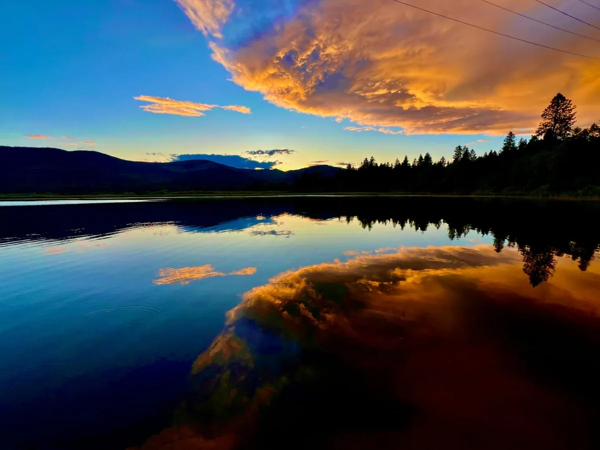 골든아워 풍경 사진 — 일몰 직전 황금빛 하늘과 호수 반영, 광각렌즈로 촬영한 드라마틱한 풍경